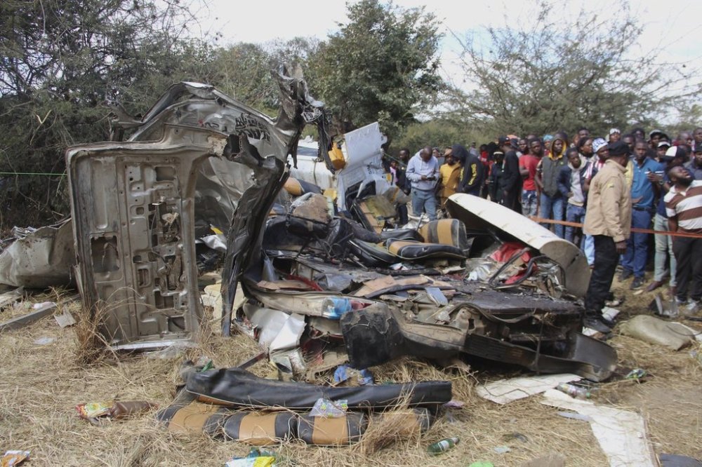 People gather at the site of a road collision between a minibus taxi and a haulage truck in Chitungwiza, Zimbabwe, Tuesday, July 22, 2025. (AP Photo)