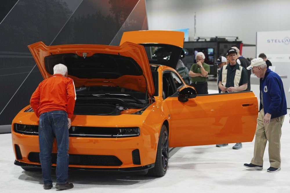 FILE - Shoppers look over a 2025 Dodge Charger Daytona hardtop in the Stellantis display at the Colorado Auto Show, April 17, 2025, in Denver. (AP Photo/David Zalubowski, File)
