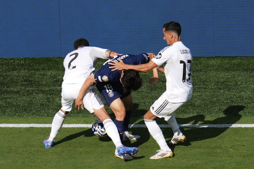 Real Madrid's Dani Carvajal (2) and Lucas Vazquez (17) compete against Paris Saint-Germain's Lee Kang-in (19) for control of the ball during the Club World Cup semifinal soccer match between PSG and Real Madrid in East Rutherford, N.J., Wednesday, July 9, 2025. (AP Photo/Pamela Smith)