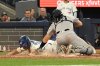Toronto Blue Jays' Davis Schneider (36) slides safely into home ahead of a tag by New York Yankees catcher Austin Wells (28) in sixth inning MLB baseball action in Toronto on Tuesday, July 22, 2025. THE CANADIAN PRESS/Jon Blacker