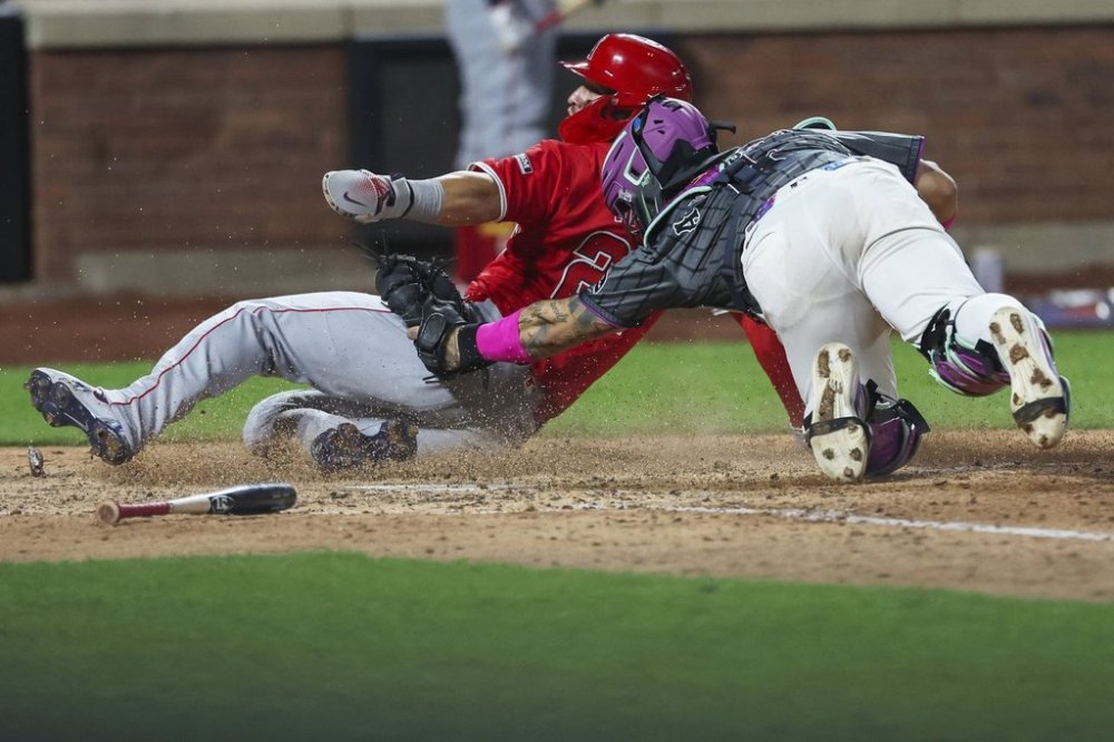 Los Angeles Angels' Mike Trout, left, is tagged out at home plate by New York Mets catcher Francisco Alvarez, right, during the seventh inning of a baseball game, Monday, July 21, 2025, in New York. (AP Photo/Heather Khalifa)