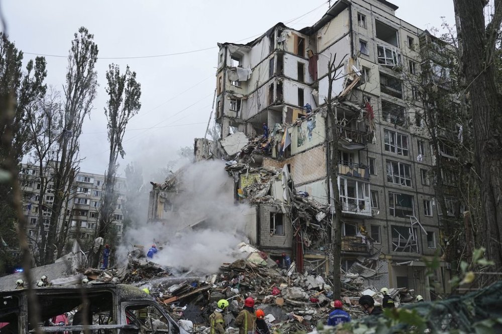 Rescuers work in a destroyed apartment building after a Russian missile attack in Kyiv, Ukraine, Thursday, July 31, 2025. (AP Photo/Efrem Lukatsky)