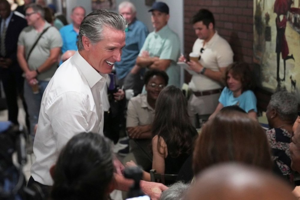 Gov. Gavin Newsom, D-Calif., greets people in a coffee shop during a two-day swing through South Carolina on Tuesday, July 8, 2025, in Florence, S.C. (AP Photo/Meg Kinnard)