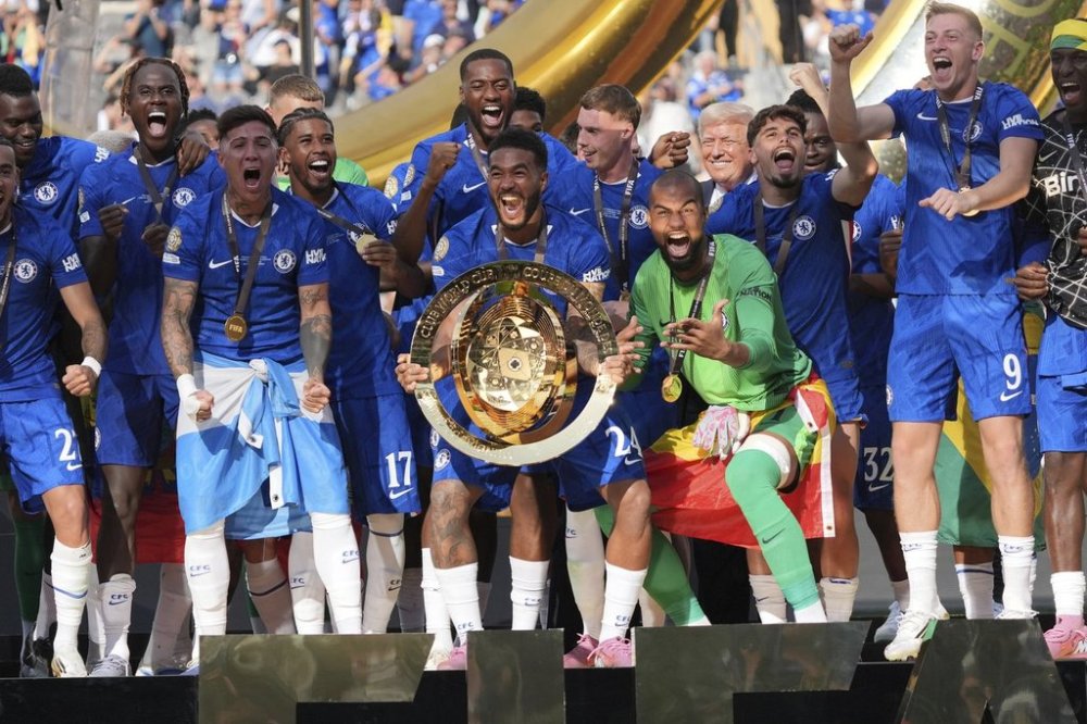President Donald Trump, back from fourth from right, stands on stage after presenting the championship trophy to Chelsea following the Club World Cup final soccer match between Chelsea and PSG at MetLife Stadium in East Rutherford, N.J., Sunday, July 13, 2025. (AP Photo/Jacquelyn Martin)