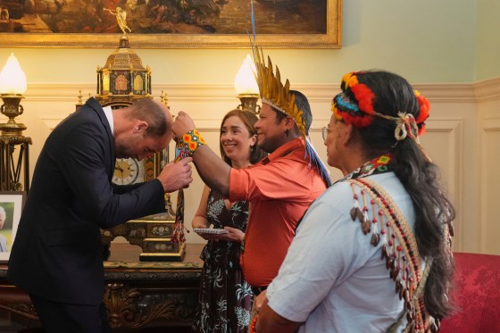 Britain's Prince William, the Prince of Wales, receives a gift from Kleber Karipuna, Indigenous leader of the Karipuna people from Amapa, centre, Jennifer Lasimbang, Former Member of Sabah State Legislative Assembly, second right, and Juan Carlos Jintiach, General Secretary for The Global Alliance of Territorial Communities. The prince, in his role as founder of The Royal Foundation's United for Wildlife program, attended a roundtable event entitled Nature's Guardians at St James's Palace in London on June 26. (Frank Augstein  The Associated Press/ Pool)