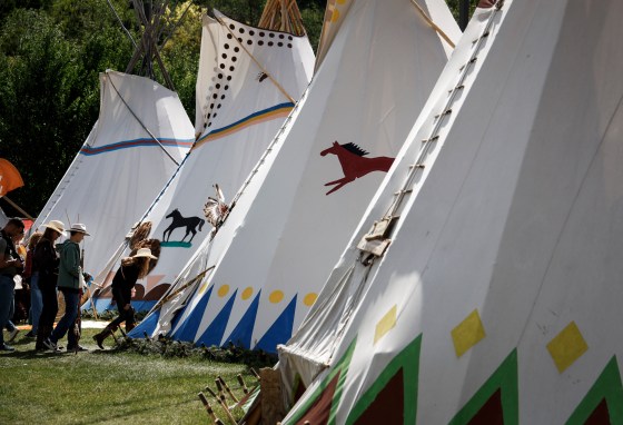 Visitors enter a teepee in the Elbow River Camp at the Calgary Stampede on July 6. (Jeff McIntosh / The Canadian Press files)