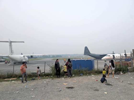 Wildfire evacuees prepare to board Canadian Armed Forces Hercules and commercial planes in Garden Hill First Nation Thursday. (Mathias Fiddler photo)
