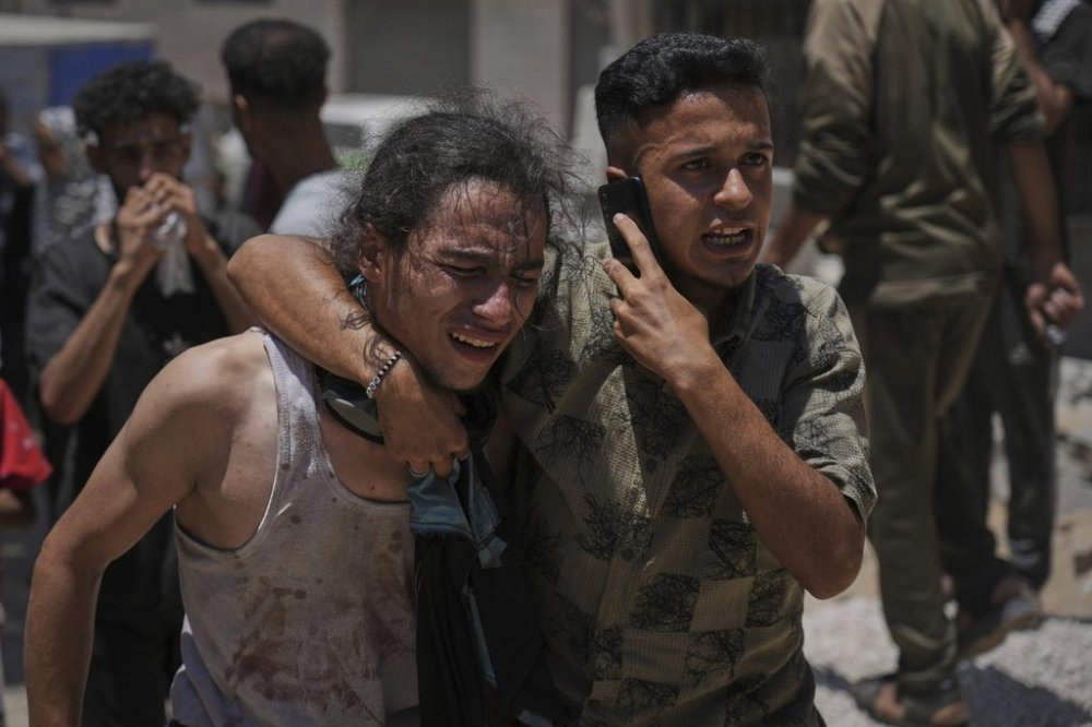 Palestinians react after carrying the bodies of those killed while trying to reach aid trucks entering northern Gaza through the Zikim crossing with Israel, at Shifa Hospital in Gaza City, Sunday, July 20, 2025. (AP Photo/Jehad Alshrafi)