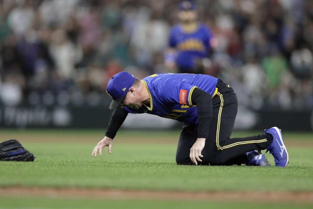 Seattle Mariners pitcher Trent Thornton goes to the ground with an injury during the ninth inning against the Texas Rangers in a baseball game Thursday, July 31, 2025, in Seattle. (AP Photo/John Froschauer)