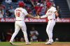 Los Angeles Angels' Mike Trout, right, and Nolan Schanuel, left, greet each other after scoring during the third inning of a baseball game against the Tampa Bay Rays, Monday, Aug. 4, 2025, in Anaheim, Calif. (AP Photo/William Liang)