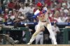 Philadelphia Phillies' Edmundo Sosa, right, hits the glove of Boston Red Sox catcher Carlos Narváez for catcher's interference with the bases loaded in the 10th inning of a baseball game Monday, July 21, 2025, in Philadelphia. (AP Photo/Matt Slocum)