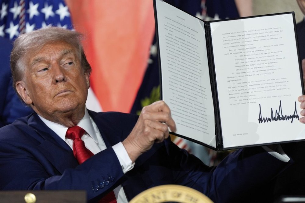President Donald Trump holds a signed executive order after speaking during an AI summit at the Andrew W. Mellon Auditorium, Wednesday, July 23, 2025, in Washington. (AP Photo/Julia Demaree Nikhinson)