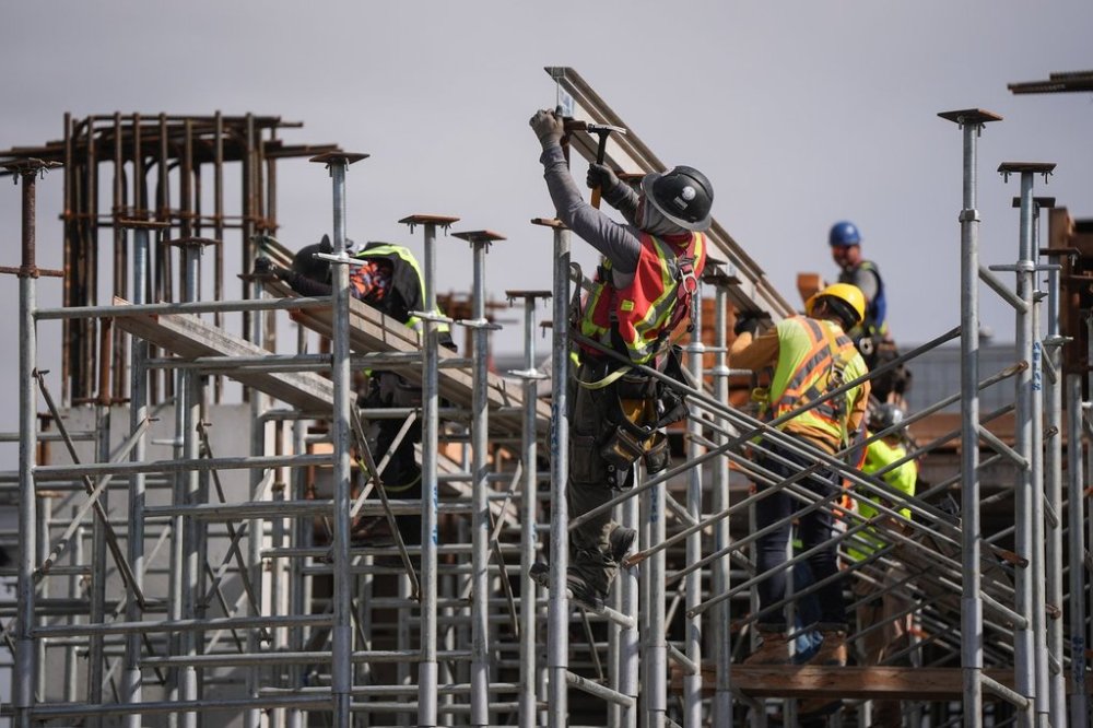Construction workers work at the site of a condo tower under construction, in Delta, B.C., on Wednesday, July 2, 2025. Six months after U.S. President Donald Trump's return the White House, many in the home construction sector say unpredictability persists around the cost and timing of obtaining the materials they need. THE CANADIAN PRESS/Darryl Dyck