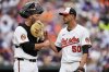 Baltimore Orioles starting pitcher Charlie Morton (50) celebrates with Baltimore Orioles catcher Jacob Stallings, left, after closing out the third inning in the first baseball game of a doubleheader against the New York Mets, Thursday, July 10, 2025, in Baltimore. (AP Photo/Stephanie Scarbrough)