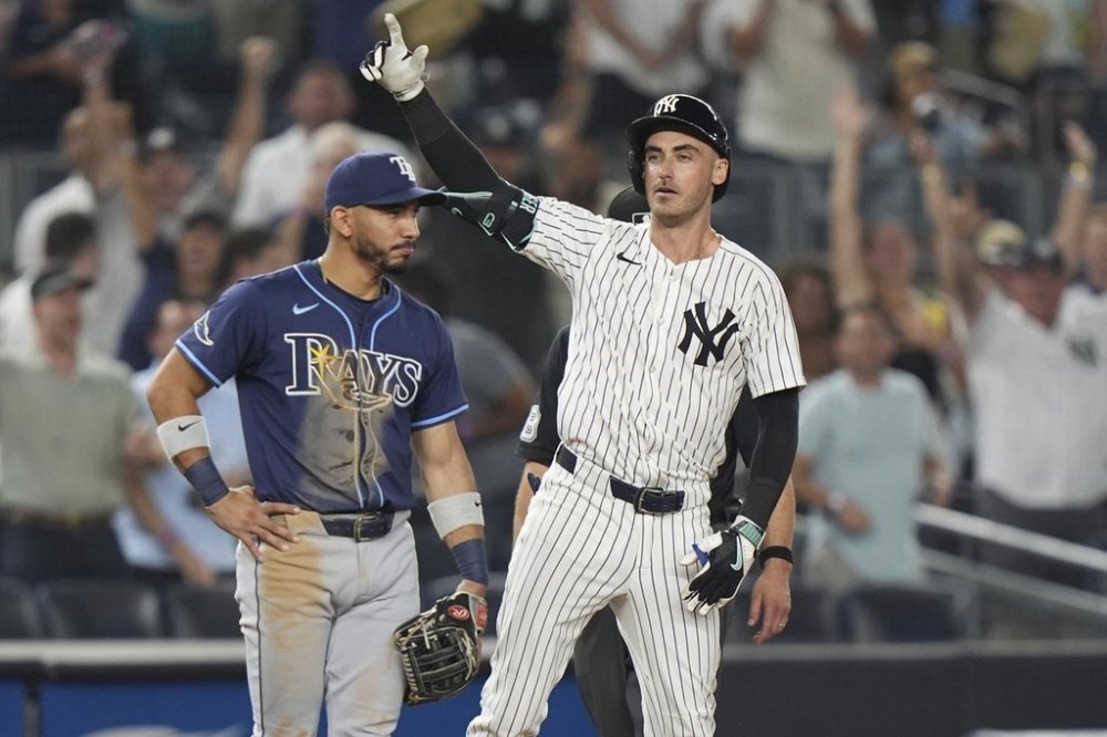 Tampa Bay Rays shortstop José Caballero watches as New York Yankees' Cody Bellinger gestures to teammates after hitting an RBI triple during the 10th inning of a baseball game Wednesday, July 30, 2025, in New York. (AP Photo/Frank Franklin II)