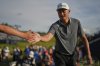 Li Haotong of China taps hands with members of the public as he walks to the 18th tee during the third round of the British Open golf championship at the Royal Portrush Golf Club, Northern Ireland, Saturday, July 19, 2025. (AP Photo/Francisco Seco)
