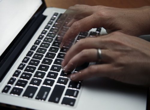 FILE - A person working on a laptop in North Andover, Mass., June 19, 2017. (AP Photo/Elise Amendola, File)