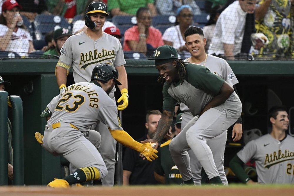 Athletics' Shea Langeliers (23) is greeted by Lawrence Butler, right, after hitting a home run against Washington Nationals pitcher MacKenzie Gore during the first inning of a baseball game in Washington, Tuesday, Aug. 5, 2025. (AP Photo/Terrance Williams)