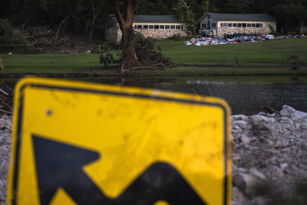 Camper's belongings sit outside one of Camp Mystic's cabins near the Guadalupe River after a flash flood swept through the area Monday, July 7, 2025, in Hunt, Texas. (AP Photo/Eli Hartman)