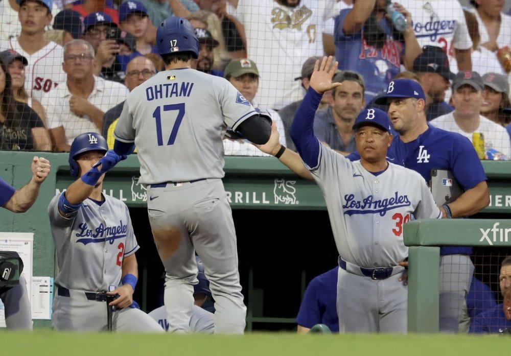 Los Angeles Dodgers designated hitter Shohei Ohtani (17) celebrates his run with a high five to manager Dave Roberts, right, during the third inning of a baseball game against the Boston Red Sox, Friday, July 25, 2025, in Boston. (AP Photo/Mark Stockwell)