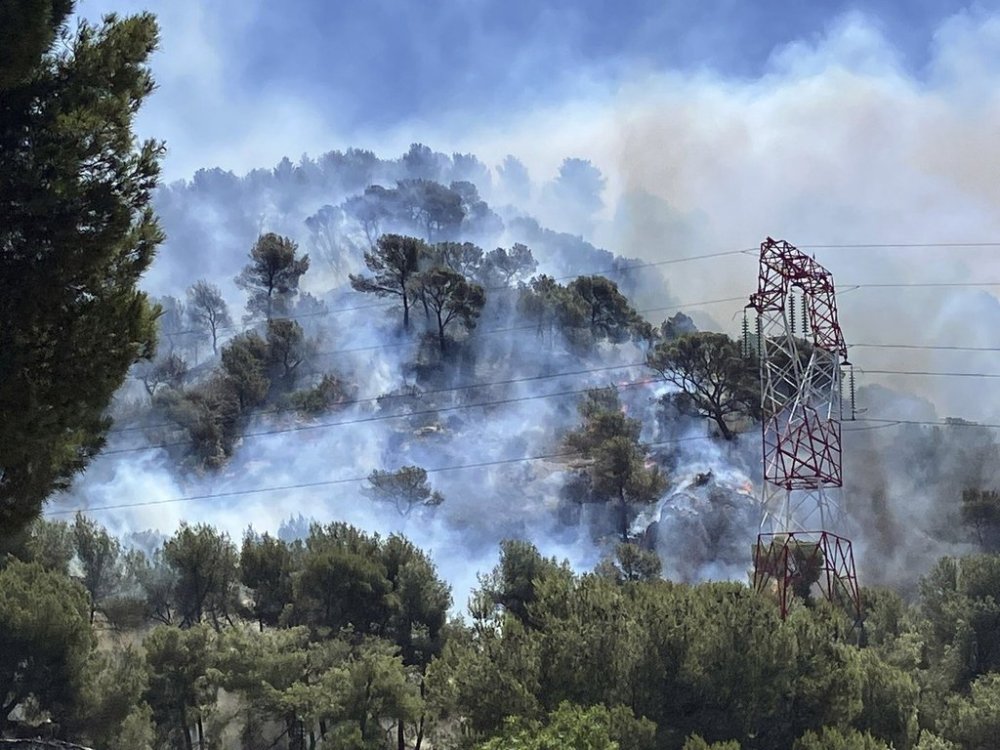 This photo provided by the fire brigade SDIS13, smoke rises during a wildfire in Pennes-Mirabeau, near Marseille, southern France, Tuesday, July 8, 2025. (SDIS13 via AP)