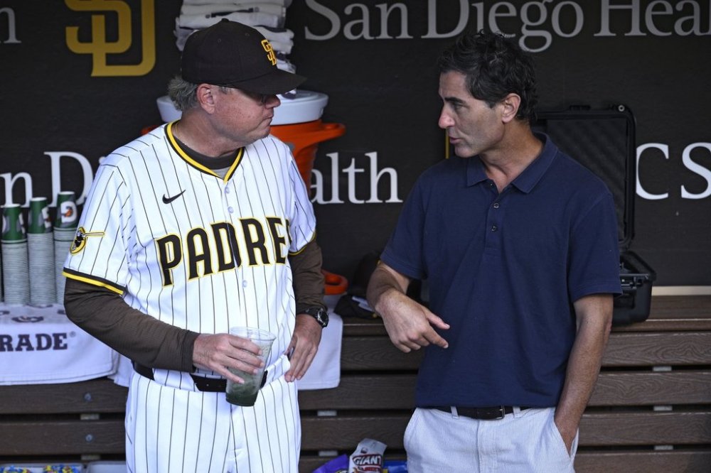 San Diego Padres manager Mike Shildt, left, and general manager A.J. Preller talk in the dugout before a baseball game against the Arizona Diamondbacks, Tuesday, July 8, 2025, in San Diego. (AP Photo/Orlando Ramirez)