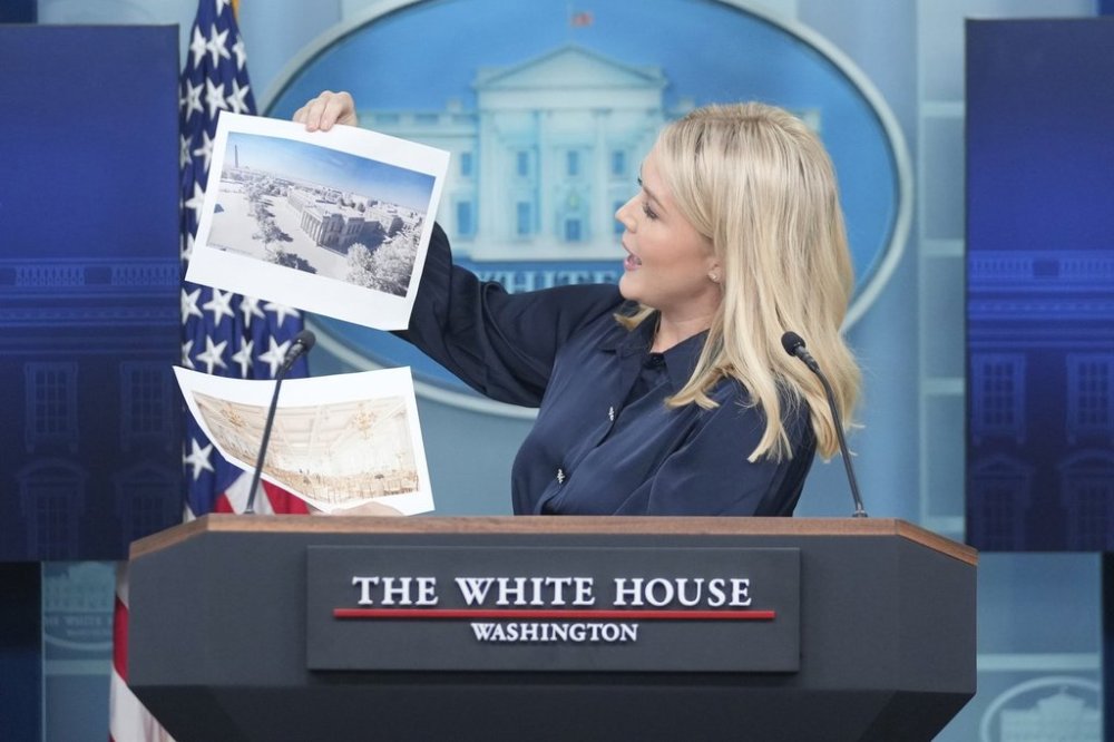 White House press secretary Karoline Leavitt holds up photos of the planned new White House ballroom during a press briefing at the White House in Washington, Thursday, July 31, 2025. (AP Photo/Mark Schiefelbein)
