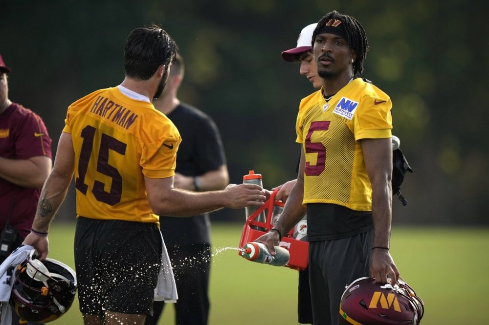Washington Commanders quarterback Jayden Daniels (5) takes a water break during practice at the team's NFL football training camp, Sunday, July 27, 2025, in Ashburn, Va. (AP Photo/Mark Schiefelbein)