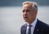 Prime Minister Mark Carney listens while touring the Royal Canadian Navy torpedo recovery vessel Sikanni at the Canadian Forces Maritime Experimental and Test Ranges (CFMETR), in Nanoose Bay, B.C., on Monday, Aug. 4, 2025. THE CANADIAN PRESS/Darryl Dyck