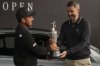 Xander Schauffele of the United States, left, winner of the 2024 British Open, hands back the Claret Jug trophy to the R&A CEO Mark Darbon ahead of the 2025 British Open golf championship at the Royal Portrush Golf Club, Northern Ireland, Monday, July 14, 2025. (AP Photo/Fransisco Seco)