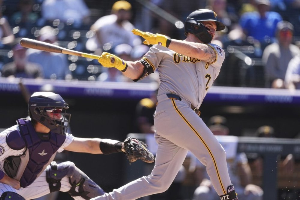 Pittsburgh Pirates' Spencer Horwitz grounds out to drive in a run as Colorado Rockies catcher Hunter Goodman covers his position in the eighth inning of a baseball game, Sunday, Aug. 3, 2025, in Denver. (AP Photo/David Zalubowski)