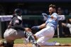 Kansas City Royals' John Rave (16) scores off a Luke Maile double as Cleveland Guardians catcher Bo Naylor, left, is unable to hold onto the ball during the fourth inning of a baseball game in Kansas City, Mo., Sunday, July 27, 2025. (AP Photo/Colin E. Braley)