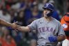 Texas Rangers' Wyatt Langford is congratulated after hitting a two-run home run during the seventh inning of a baseball game against the Houston Astros, Friday, July 11, 2025, in Houston. (AP Photo/Kevin M. Cox)