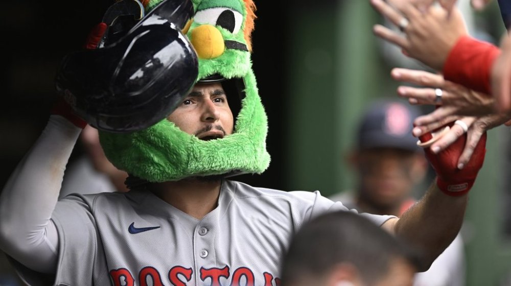 Boston Red Sox's Wilyer Abreu celebrates with teammates in the dugout while wearing the green monster mask after hitting a solo home run during the eighth inning of a baseball game against the Chicago Cubs, Sunday, July 20, 2025, in Chicago. (AP Photo/Paul Beaty)
