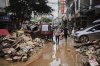 FILE -In this photo released by Xinhua News Agency, residents wade through debris along a flood-hit street after waters from a river overwhelmed towns following days of heavy rain, in Huaiji County, south China's Guangdong Province on June 19, 2025. (Deng Hua/Xinhua via AP, File)