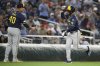 Milwaukee Brewers' Blake Perkins, right, celebrates his two-run home run with third base coach Jason Lane (40) during the fifth inning of a baseball game against the Washington Nationals, Friday, Aug. 1, 2025, in Washington. (AP Photo/Nick Wass)