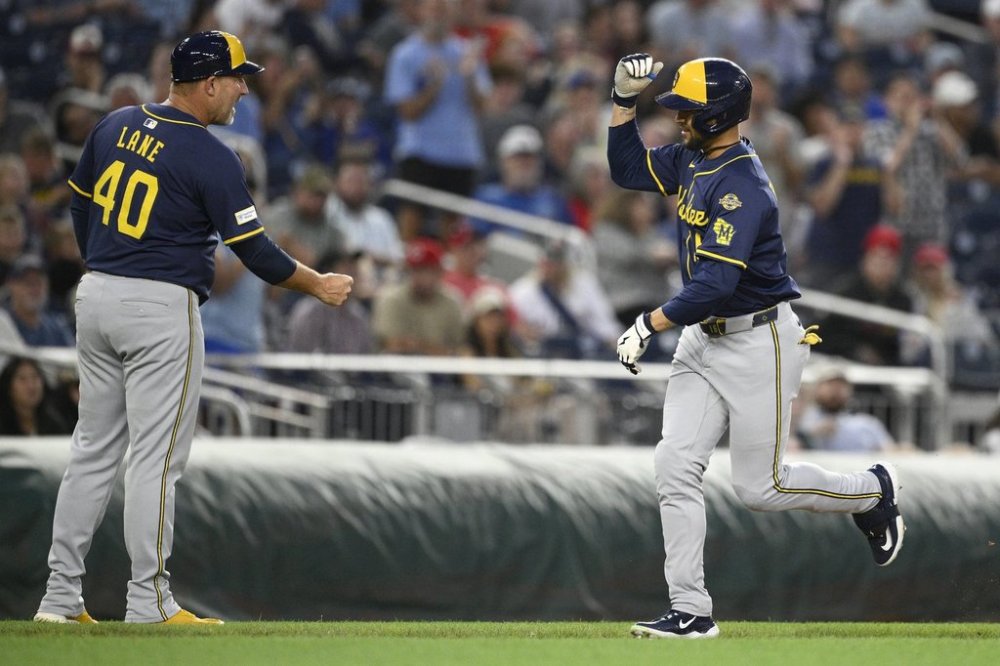 Milwaukee Brewers' Blake Perkins, right, celebrates his two-run home run with third base coach Jason Lane (40) during the fifth inning of a baseball game against the Washington Nationals, Friday, Aug. 1, 2025, in Washington. (AP Photo/Nick Wass)