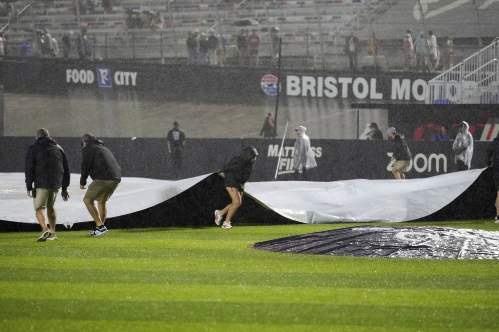 Member of the ground cover the field during a rain delay in the first inning of the MLB Speedway Classic baseball game at Bristol Motor Speedway in Bristol, Tenn., Saturday, Aug. 2, 2025. (AP Photo/George Walker IV)