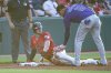 Colorado Rockies' Orlando Arcia (11) is late with the tag as Cleveland Guardians' Nolan Jones is safe at third base after a wild pick off throw at second during the third inning of a baseball game, Tuesday, July 29, 2025, in Cleveland. (AP Photo/Phil Long)