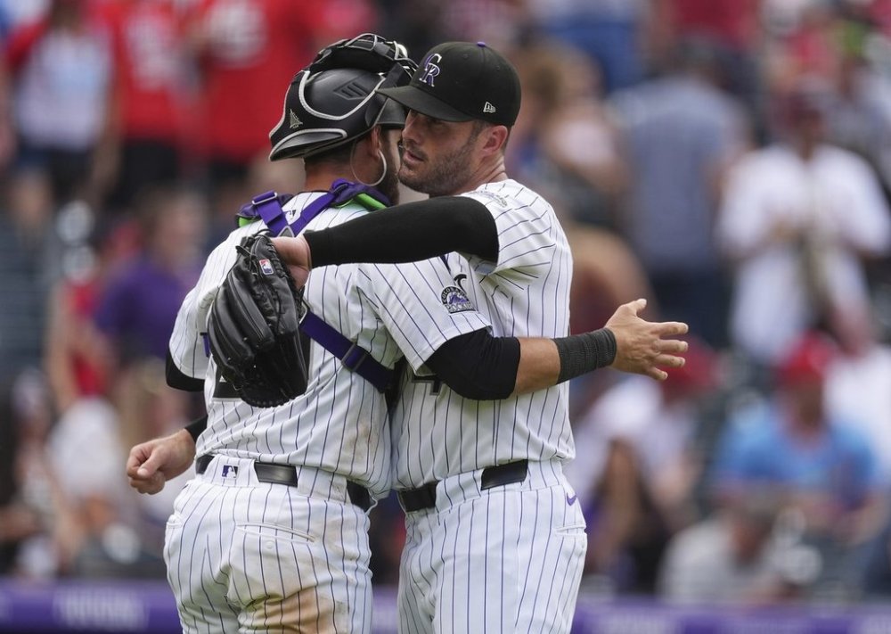 Colorado Rockies catcher Austin Nola, left, hugs relief pitcher Tyler Kinley after defeating the St. Louis Cardinals in a baseball game Wednesday, July 23, 2025, in Denver. (AP Photo/David Zalubowski)