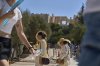 Tourist walk outside the Acropolis of Athens, on Monday, July 7, 2025 while authorities in Greece have imposed mandatory work stoppages in parts of the country where temperatures are expected to exceed 40 degrees Celsius (104 Fahrenheit) (AP Photo/Petros Giannakouris)
