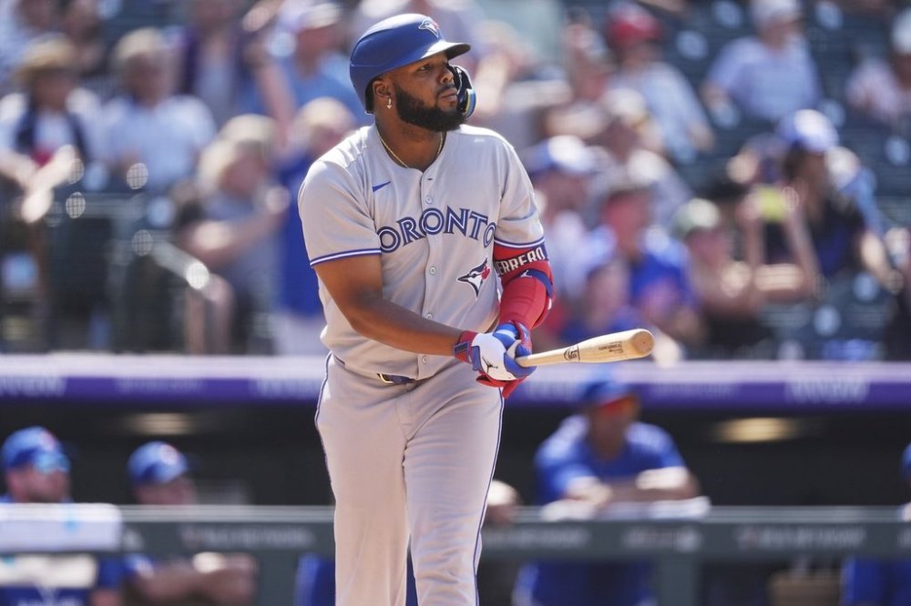 Toronto Blue Jays' Vladimir Guerrero Jr. follows the flight of his solo home run off Colorado Rockies relief pitcher Victor Vodnik in the eighth inning of a baseball game Wednesday, Aug. 6, 2025, in Denver. (AP Photo/David Zalubowski)