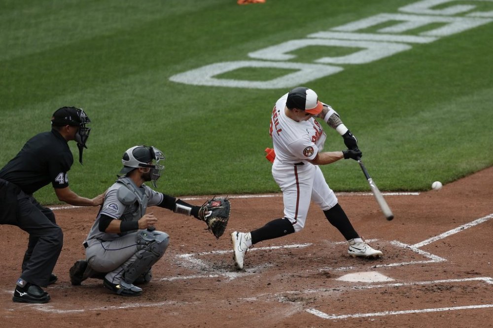 Baltimore Orioles' Tyler O'Neill, right, hits a two-run home run off Colorado Rockies pitcher Austin Gomber during the third inning of a baseball game in Baltimore, Sunday, July 27, 2025. (AP Photo/Terrance Williams)