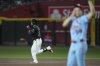 Arizona Diamondbacks' Eugenio Suárez, left, rounds the bases after hitting a two-run home run against St. Louis Cardinals starting pitcher Sonny Gray, right, during the first inning of a baseball game Saturday, July 19, 2025, in Phoenix. (AP Photo/Ross D. Franklin)