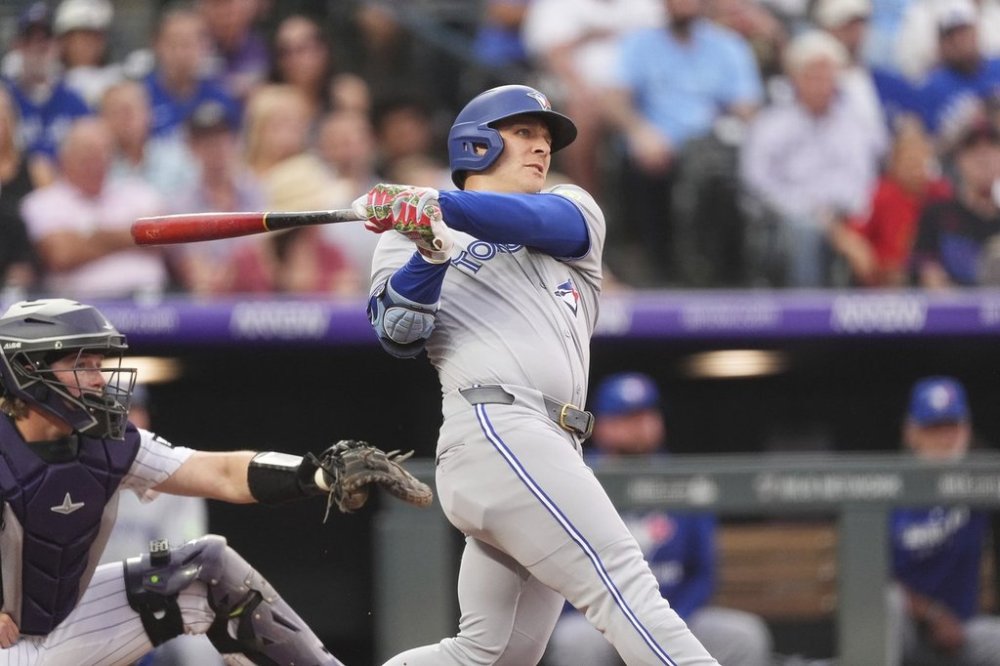 Toronto Blue Jays' Daulton Varsho hits a two-run home run off Colorado Rockies starting pitcher Anthony Molina in the fourth inning of a baseball game Tuesday, Aug. 5, 2025, in Denver. (AP Photo/David Zalubowski)