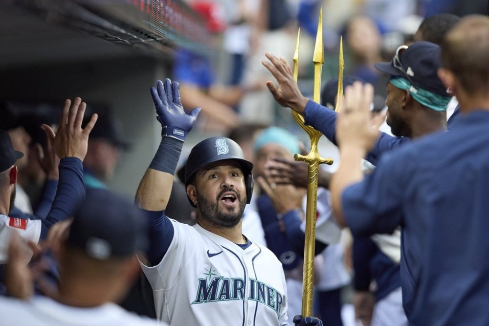 Seattle Mariners' Eugenio Suárez celebrates in the dugout his two RBI home run off Chicago White Sox starting pitcher Davis Martin during the fourth inning of a baseball game, Tuesday, Aug. 5, 2025, in Seattle. (AP Photo/John Froschauer)