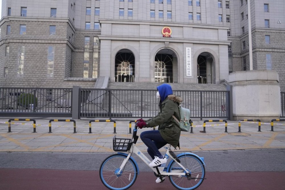 FILE - A cyclist rides past outside the Beijing No.2 Intermediate People's Court, March 31, 2022, in Beijing. (AP Photo/Ng Han Guan, File)