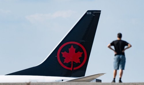 A potential strike looms as contract talks carry on between Air Canada and the union representing 10,000 of its flight attendants. A person watches as an Air Canada plane lands at Montreal-Pierre Elliott Trudeau International Airport in Montreal, Friday, Sept. 13, 2024.  THE CANADIAN PRESS/Christinne Muschi