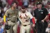 San Diego Padres' Manny Machado, left, is held back by St. Louis Cardinals' Willson Contreras (40) after being hit by a pitch as home plate umpire Lance Barrett, right, watches during the ninth inning of a baseball game against the St. Louis Cardinals Saturday, July 26, 2025, in St. Louis. (AP Photo/Jeff Roberson)
