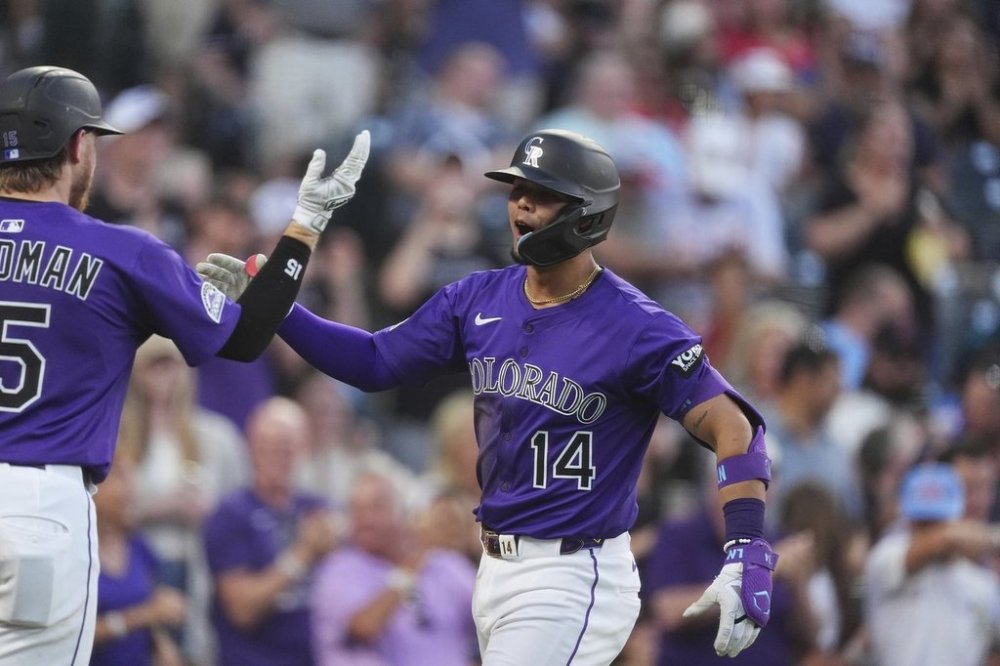 Colorado Rockies' Hunter Goodman, left, congratulates Ezequiel Tovar as he crosses home plate after hitting a two-run home run off Minnesota Twins relief pitcher Brock Stewart in the fifth inning of a baseball game Saturday, July 19, 2025, in Denver. (AP Photo/David Zalubowski)